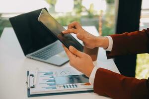 Financial analysts analyze business financial reports on a digital tablet planning investment project during a discussion at a meeting of corporate showing the results of their successful teamwork. photo