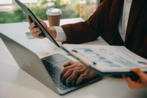 Financial analysts analyze business financial reports on a digital tablet planning investment project during a discussion at a meeting of corporate showing the results of their successful teamwork. photo