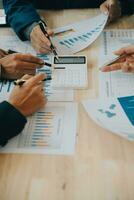 Financial analysts analyze business financial reports on a digital tablet planning investment project during a discussion at a meeting of corporate showing the results of their successful teamwork. photo