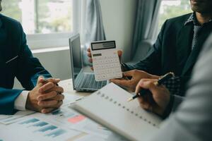 Financial analysts analyze business financial reports on a digital tablet planning investment project during a discussion at a meeting of corporate showing the results of their successful teamwork. photo