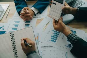 Financial analysts analyze business financial reports on a digital tablet planning investment project during a discussion at a meeting of corporate showing the results of their successful teamwork. photo