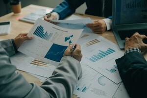 Financial analysts analyze business financial reports on a digital tablet planning investment project during a discussion at a meeting of corporate showing the results of their successful teamwork. photo
