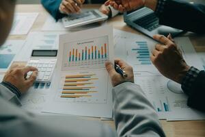 Financial analysts analyze business financial reports on a digital tablet planning investment project during a discussion at a meeting of corporate showing the results of their successful teamwork. photo