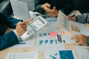 Financial analysts analyze business financial reports on a digital tablet planning investment project during a discussion at a meeting of corporate showing the results of their successful teamwork. photo
