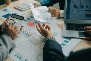 Financial analysts analyze business financial reports on a digital tablet planning investment project during a discussion at a meeting of corporate showing the results of their successful teamwork. photo