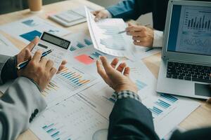 Financial analysts analyze business financial reports on a digital tablet planning investment project during a discussion at a meeting of corporate showing the results of their successful teamwork. photo
