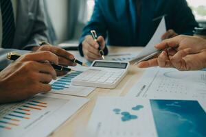 Financial analysts analyze business financial reports on a digital tablet planning investment project during a discussion at a meeting of corporate showing the results of their successful teamwork. photo