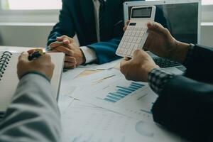 Financial analysts analyze business financial reports on a digital tablet planning investment project during a discussion at a meeting of corporate showing the results of their successful teamwork. photo