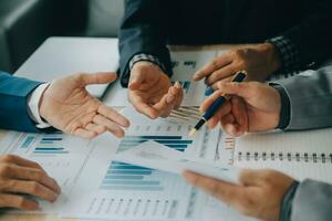 Financial analysts analyze business financial reports on a digital tablet planning investment project during a discussion at a meeting of corporate showing the results of their successful teamwork. photo