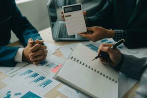 Financial analysts analyze business financial reports on a digital tablet planning investment project during a discussion at a meeting of corporate showing the results of their successful teamwork. photo