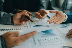 Financial analysts analyze business financial reports on a digital tablet planning investment project during a discussion at a meeting of corporate showing the results of their successful teamwork. photo