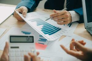 Financial analysts analyze business financial reports on a digital tablet planning investment project during a discussion at a meeting of corporate showing the results of their successful teamwork. photo