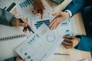 Financial analysts analyze business financial reports on a digital tablet planning investment project during a discussion at a meeting of corporate showing the results of their successful teamwork. photo