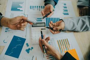 Financial analysts analyze business financial reports on a digital tablet planning investment project during a discussion at a meeting of corporate showing the results of their successful teamwork. photo