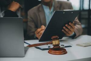 Business and lawyers discussing contract papers with brass scale on desk in office. Law, legal services, advice, justice and law concept picture with film grain effect photo