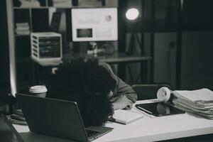 Asian woman overwork and sleep on the table after she feeling very try.Depression and anxiety.Chinese office girl sleeping after can not find data and solution to do her report.Workaholic people. photo