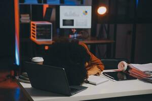 Asian woman overwork and sleep on the table after she feeling very try.Depression and anxiety.Chinese office girl sleeping after can not find data and solution to do her report.Workaholic people. photo