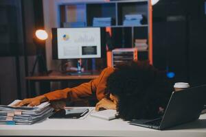 Asian woman overwork and sleep on the table after she feeling very try.Depression and anxiety.Chinese office girl sleeping after can not find data and solution to do her report.Workaholic people. photo