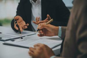 Business and lawyers discussing contract papers with brass scale on desk in office. Law, legal services, advice, justice and law concept picture with film grain effect photo