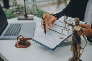 Business and lawyers discussing contract papers with brass scale on desk in office. Law, legal services, advice, justice and law concept picture with film grain effect photo