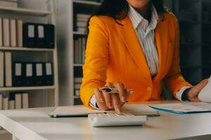 Close up woman work on project sit at desk use laptop and calculator, look at pc screen with diagrams, calculates bills, check financial documents, leads accounting of company, plan investment concept photo