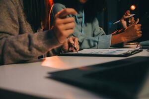 Team of software developers working on big project late at night in neon light trying to finish before deadline photo