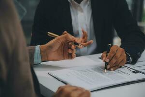 Business and lawyers discussing contract papers with brass scale on desk in office. Law, legal services, advice, justice and law concept picture with film grain effect photo