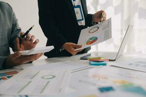 Financial analysts analyze business financial reports on a digital tablet planning investment project during a discussion at a meeting of corporate showing the results of their successful teamwork. photo