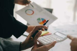 Financial analysts analyze business financial reports on a digital tablet planning investment project during a discussion at a meeting of corporate showing the results of their successful teamwork. photo