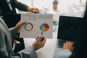 Financial analysts analyze business financial reports on a digital tablet planning investment project during a discussion at a meeting of corporate showing the results of their successful teamwork. photo