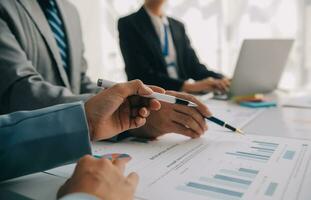 Financial analysts analyze business financial reports on a digital tablet planning investment project during a discussion at a meeting of corporate showing the results of their successful teamwork. photo