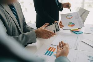 Financial analysts analyze business financial reports on a digital tablet planning investment project during a discussion at a meeting of corporate showing the results of their successful teamwork. photo