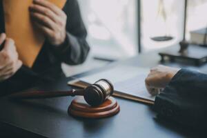 Business and lawyers discussing contract papers with brass scale on desk in office. Law, legal services, advice, justice and law concept picture with film grain effect photo