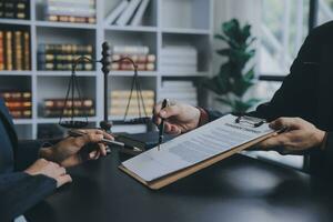 Business and lawyers discussing contract papers with brass scale on desk in office. Law, legal services, advice, justice and law concept picture with film grain effect photo