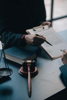 Justice and law concept.Male judge in a courtroom with the gavel, working with, computer and docking keyboard, eyeglasses, on table in morning light photo
