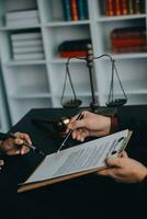 Justice and law concept.Male judge in a courtroom with the gavel, working with, computer and docking keyboard, eyeglasses, on table in morning light photo