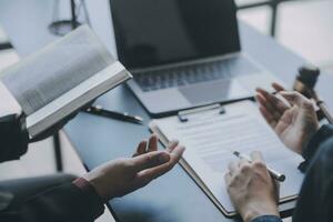 Business and lawyers discussing contract papers with brass scale on desk in office. Law, legal services, advice, justice and law concept picture with film grain effect photo