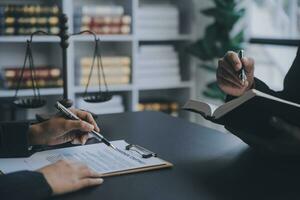 Business and lawyers discussing contract papers with brass scale on desk in office. Law, legal services, advice, justice and law concept picture with film grain effect photo