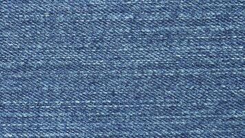 fechar-se macro azul jeans jeans tecido avião superfície fundo. têxtil textura monitorando. controle deslizante panela tomada. video