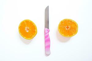 Sliced tangerine isolated on a white background with a knife. Top view, copy space. photo