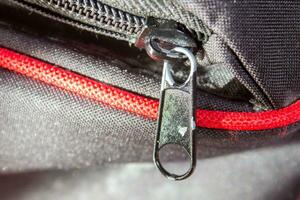 Metal zipper on a black bag, closeup photo