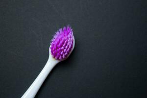 Used old purple toothbrush isolated on a black background. Top view, copy space for text. photo