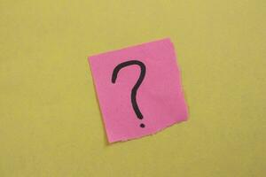 Question mark drawn on a pink paper. Curiosity, uncertainty and confusion concepts. Conceptual image. photo