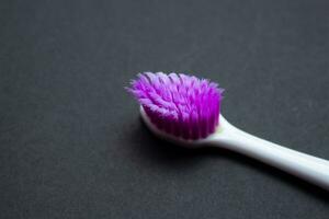 Used old purple toothbrush isolated on a black background. Top view, copy space for text. photo