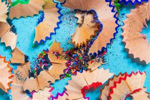 Pencil shavings isolated on a blue background. Top view, flat lay. photo