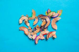 Pencil shavings isolated on a blue background. Top view, flat lay. photo