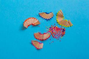 Pencil shavings isolated on a blue background. Top view, flat lay. photo