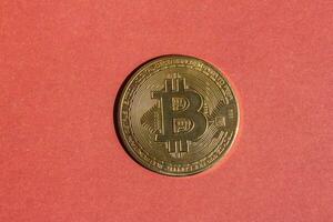 Golden bitcoin isolated on a red background. Top view, flat lay. photo