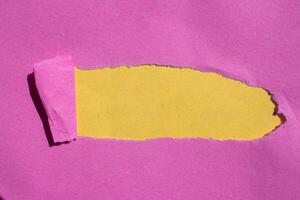 Pink torn paper on a yellow background photo