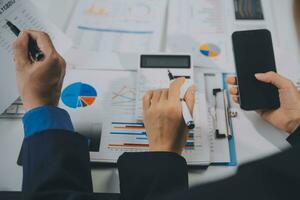 Financial analysts analyze business financial reports on a digital tablet planning investment project during a discussion at a meeting of corporate showing the results of their successful teamwork. photo